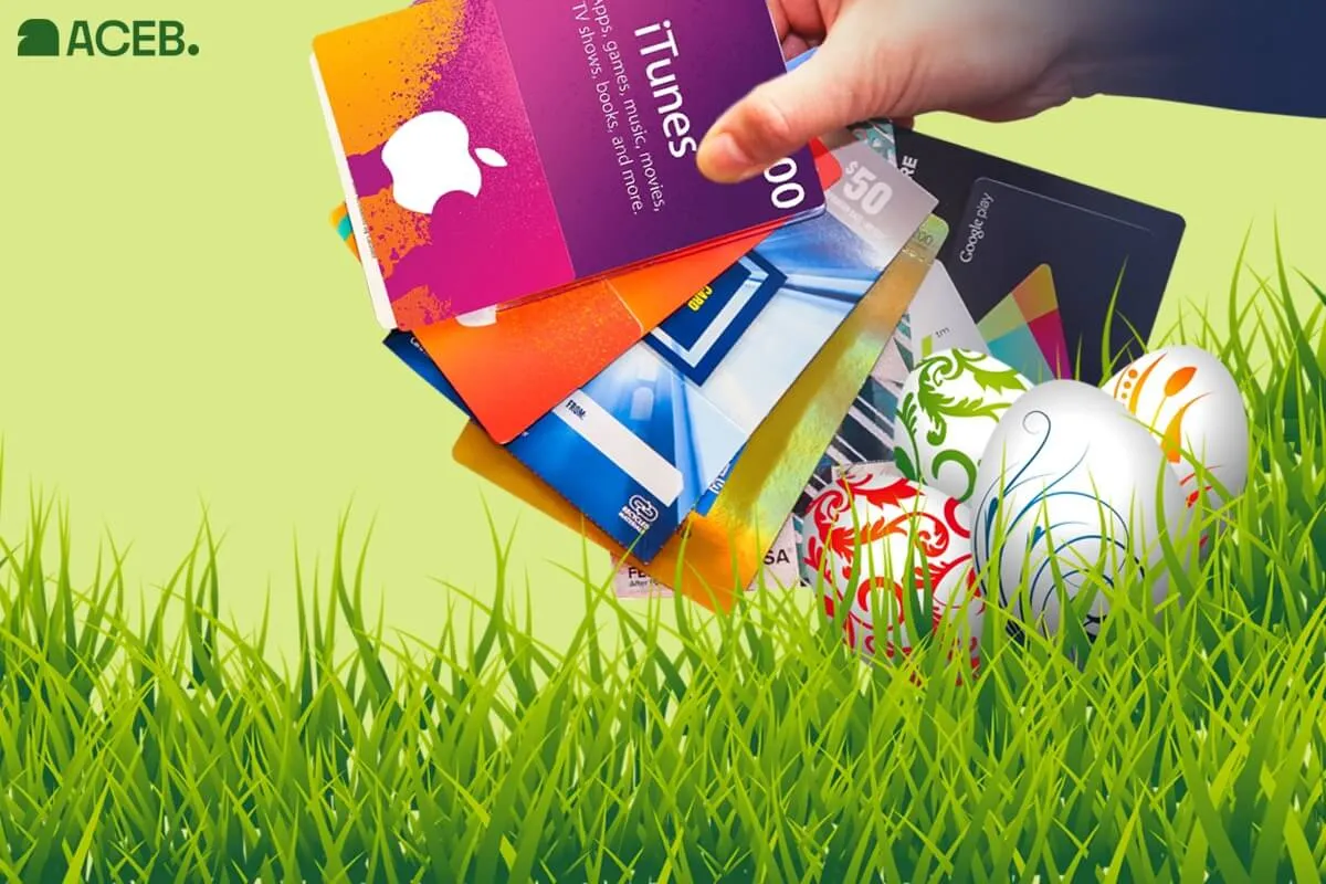 Hand holding iTunes and Google Play gift cards placed in grass with Easter eggs